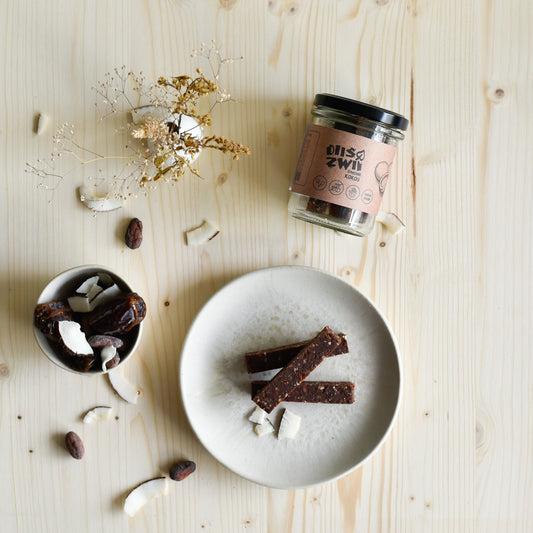 Veganer Kokosriegel einzeln und im Glas präsentiert, natürlich süss und ohne Zuckerzusatz, handgemacht in der Schweiz.